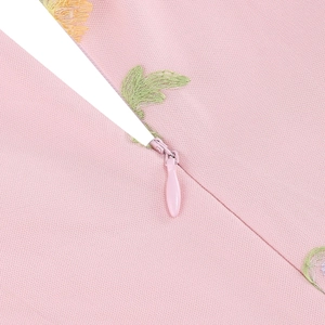 Dettaglio della cerniera invisibile e del ricamo floreale sull'abito rosa cipria