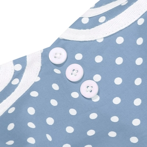 Macro shot of white buttons and lace trim on a retro blue polka dot cotton midi dress