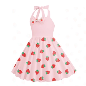 Dettaglio di un abito rosa a trapezio con stampe di fragole e un fiocco decorativo rosa