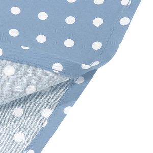 Detailed close-up of blue cotton fabric with white polka dots and neat stitching edge