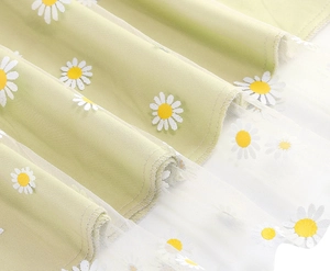 Close-up of double-layer light green mesh skirt fabric with white daisy floral prints