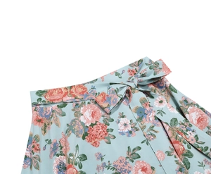 Detail view of the floral print waistline featuring a tied bow belt on a blue A-line skirt