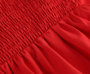Vue macro détaillée du tissu satin rouge avec smocks artisanaux et textures plissées