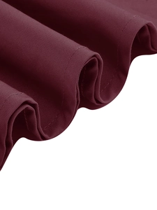 Dettaglio dell'orlo del vestito bordeaux con trama del tessuto e pieghe a onda