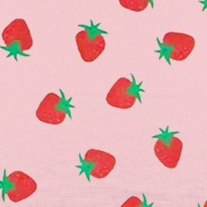 Dettaglio del motivo con fragole rosse e foglie verdi su tessuto di cotone rosa bimba
