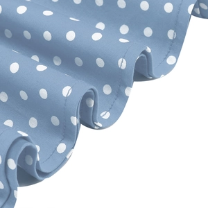 Detailed view of light blue polka dot fabric hem with professional stitching and draping