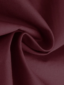 Dettaglio ravvicinato del tessuto saia rosso vino con texture setosa e drappeggio