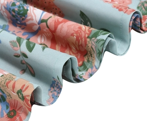 Detailed close-up of the vintage floral print and stitched hem on the light cyan skirt