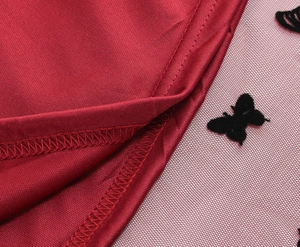 Dettaglio gonna in raso rosso con tulle a farfalle nere e cuciture di precisione