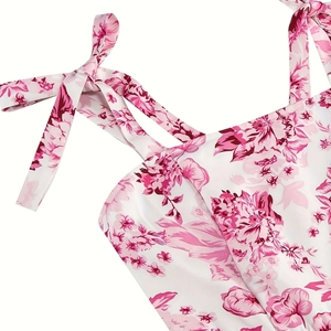 Detail of floral print summer dress featuring pink tie-shoulder straps and square neckline