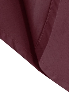 Dettaglio macro della trama del tessuto rosso vino e cuciture pulite sull'abito