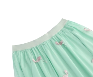 Detail of pink flamingo embroidery on tiered mint green mesh high-waisted skirt