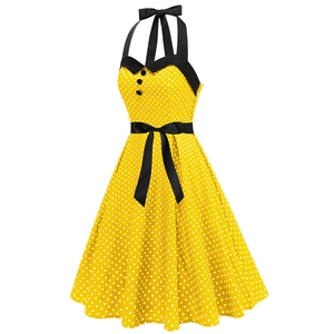 Détail d'une robe vintage à pois jaune avec décolleté en cœur noir et boutons décoratifs