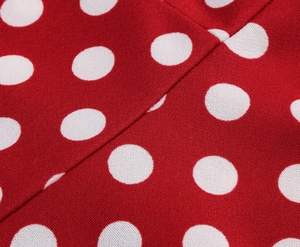Detailed macro view of red polka dot printed fabric texture for summer party dress