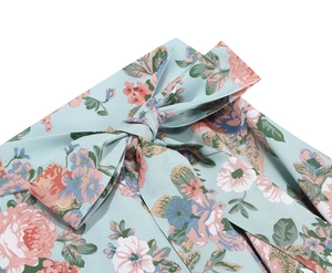 Detail of light blue floral print fabric with a delicate ribbon bow decoration