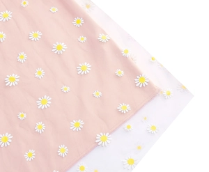 Detail of pink fabric featuring white daisy embroidery and double-layer mesh overlay
