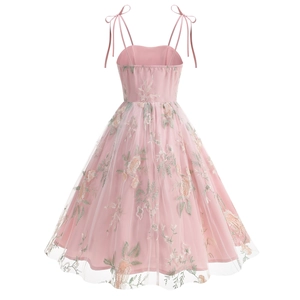 Detailed close-up of intricate floral embroidery and tulle fabric on the pink dress