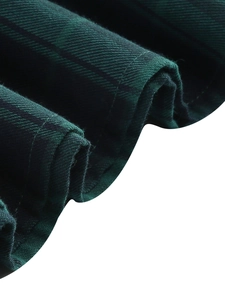 Detail of dark green plaid fabric showing twill weave structure and neat stitched edges