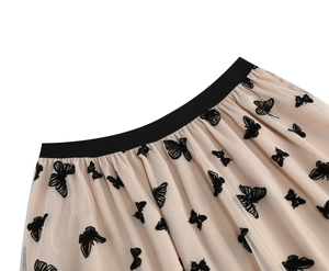 Dettaglio della gonna in tulle beige con ricami di farfalle nere ed elastico in vita