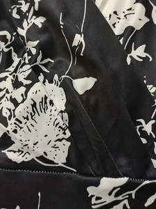 Detailed close-up of floral print fabric with vertical texture on a black v-neck dress