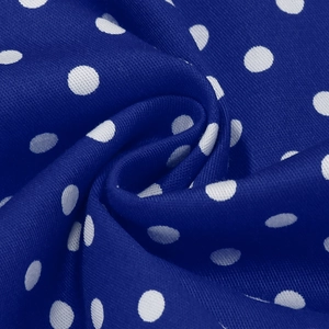 Vue détaillée du tissu bleu à pois blancs avec texture douce et motif vintage