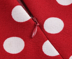 Close-up of invisible red zipper with teardrop pull on red polka dot lace dress