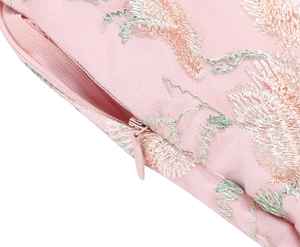 Detail of pink embroidered floral dress featuring sheer mesh fabric and invisible zipper
