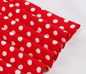 Dettaglio del tessuto rosso vintage a pois bianchi con pieghe per abiti da bambina