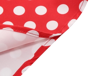 Gros plan détaillé des coutures et de l'ourlet du tissu rouge à pois blancs