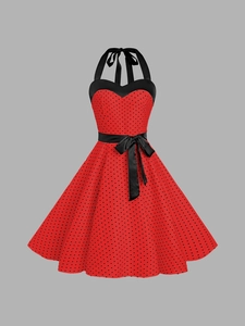 Détail de robe rouge à pois avec licou et ceinture en ruban noir à la taille