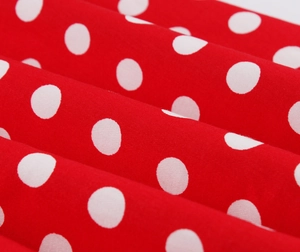 Dettaglio del tessuto di cotone rosso a pois bianchi con trama e pieghe naturali