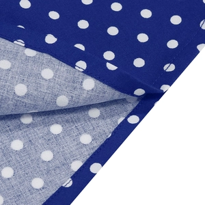 Gros plan du tissu bleu à pois montrant les coutures soignées et la texture sergé