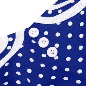 Close-up detail of white buttons and lace trim on a red polka dot cotton A-line dress