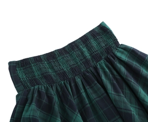 Detail view of gothic plaid skirt showing the elastic smocking waist and green tartan fabric