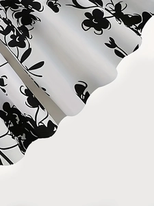Detailed close-up of floral print fabric showing elegant pleats and wavy hem texture