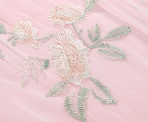Detail of pink mesh fabric featuring exquisite floral embroidery and translucent texture
