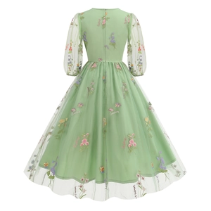 Dettaglio dell'abito in tulle verde chiaro con ricami floreali e design a strati