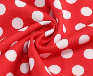 Vue macro du tissu à pois rouges avec motifs blancs et détails de tissage délicats