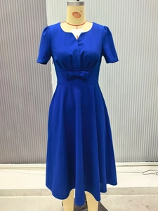 Close-up of royal blue V-neck dress with waist bow detail and elegant pleated fabric