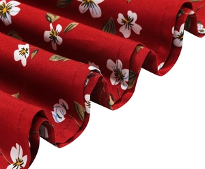 Macro detail of red floral dress showing fabric texture and ruffled stitching craft