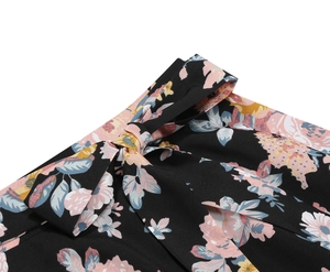 Detailed view of black floral A-line skirt waist with a delicate bow tie and pink blossoms