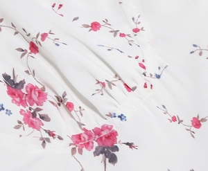 Detail view of pink rose embroidery and delicate pleated chiffon fabric on vintage dress