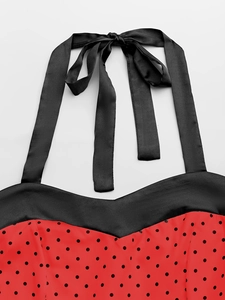 Gros plan du décolleté licou avec rubans en satin noir et motif à pois rouges