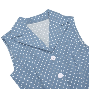 Détail d'une robe bleue à pois blancs avec col à revers et boutons décoratifs