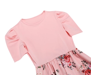 Dettaglio dell'abito estivo rosa con maniche a sbuffo e gonna a stampa floreale