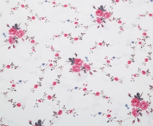 Close-up of the vintage floral embroidery and romantic pink rose pattern on white fabric