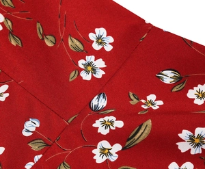 Close-up detail of red floral fabric showing neat stitching and vintage flower patterns