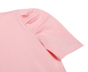 Dettaglio macro delle maniche a sbuffo plissettate e cuciture di un abito rosa floreale