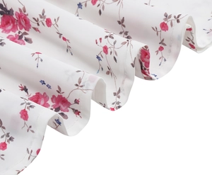 Close-up of lightweight chiffon fabric featuring pink rose embroidery and delicate pleats