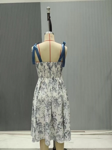 Dettaglio posteriore dell'abito a fiori bianco con spalline a fiocco e smocking